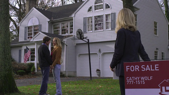 TD房地产经纪人手持“已售出”标志，一对夫妇向美国新泽西州威科夫的房子走去视频下载