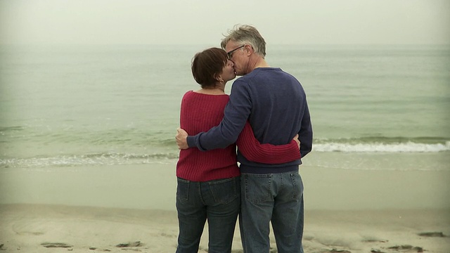 美国新泽西州的海光明，成年夫妇看着海站在水边的后视图视频下载