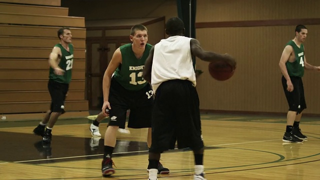 SLO MO WS PAN年轻男子在体育馆打篮球/布埃纳维斯塔，弗吉尼亚，美国视频下载