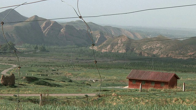 红色小屋和山脉的乡村景观/马提斯，中国甘肃视频下载