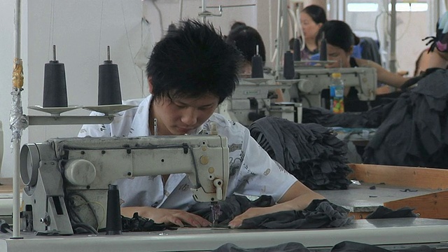 中国浙江宁波工厂的MS员工在缝纫机上工作视频素材