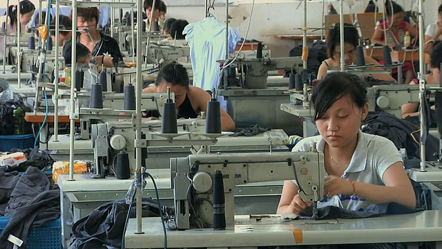 中国浙江宁波，成排的人们在缝纫机前工作视频下载