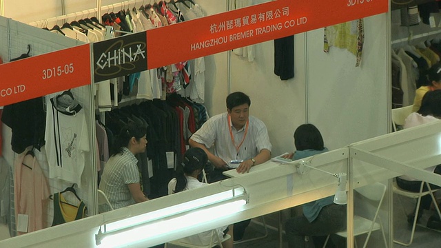 MS HA人们在服装采购展(中国香港)的展位上交谈视频下载
