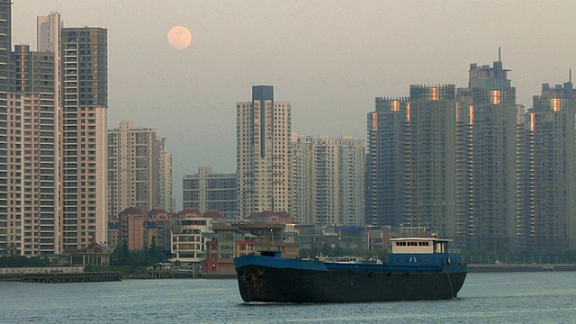 月圆之夜，中国上海，公寓楼前河上的WS油轮视频下载