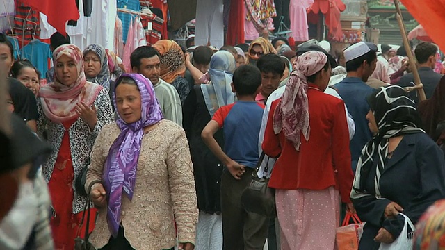 中国新疆喀什，人们穿着传统的维吾尔服装走过市场街视频下载