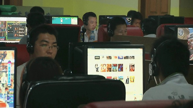 中国江苏扬州的网吧里，一排排的男人坐在电脑前视频素材