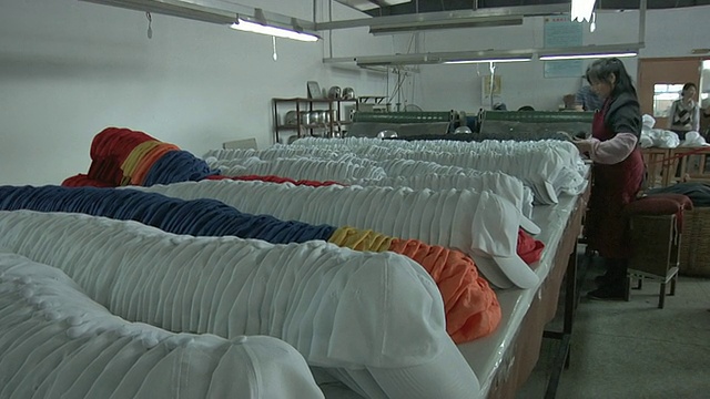 一排排棒球帽堆放在工厂包装室/江苏扬州，中国视频下载
