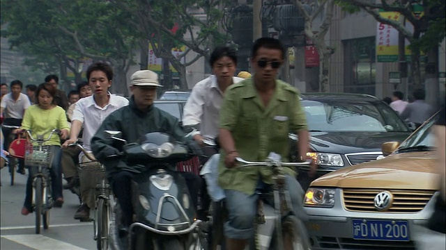 大群骑自行车的人穿过繁忙的十字路口/上海视频下载