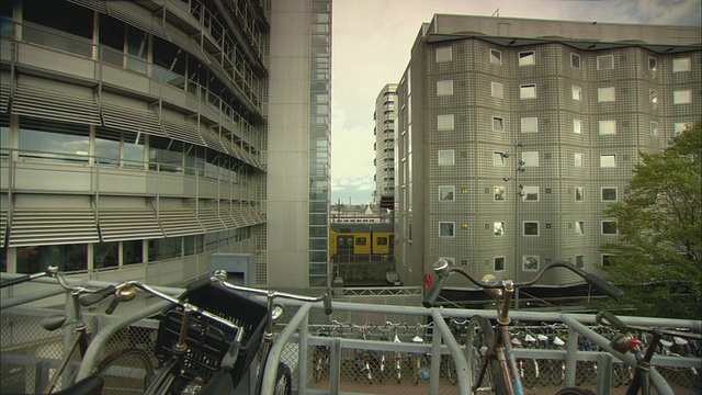 T/L MS现代办公大楼和火车停靠站，一排排自行车停在前景/荷兰阿姆斯特丹视频下载
