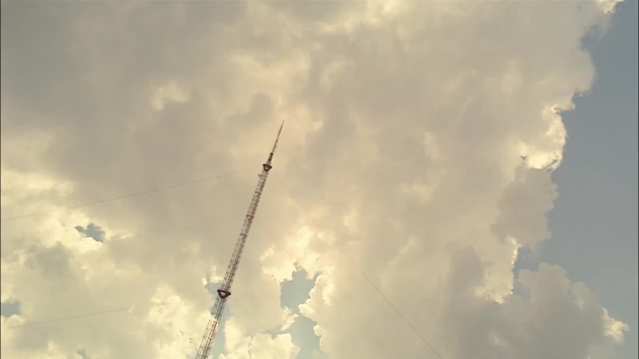 低角度拍摄的杆子对天空的云/慢动作的溜冰者表演奥利在镜头上视频下载