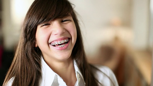 CU微笑少女的肖像(14-15岁)与矫正的牙齿/布鲁塞尔，布拉班特，比利时视频下载
