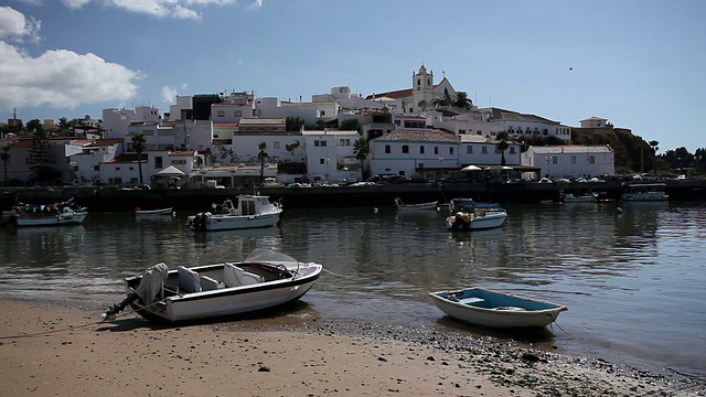 葡萄牙阿尔加维，费拉古多，停泊在港口的渔船，背景是城市景观视频素材