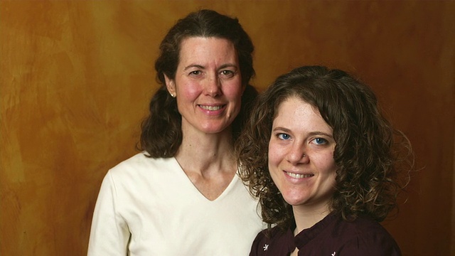 美国佛蒙特州曼彻斯特市，母亲和成年女儿靠在木板墙上的肖像视频下载