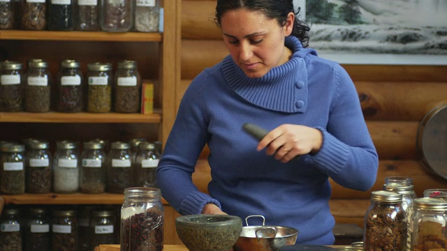 美国佛蒙特州曼彻斯特，草药师在研钵和研杵中研磨草药视频下载
