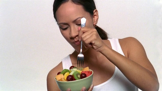 中杯的女人正在吃一碗水果沙拉视频下载