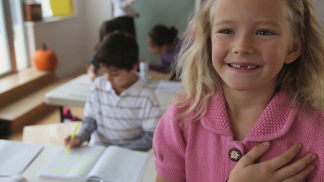 美国新泽西州泽西城，CU选择性焦点女孩(6-7岁)在教室里和其他坐在后排的孩子一起宣誓视频下载