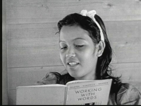 1949年，一位当地教师在黑板上讲课，当地女孩坐在长凳上观看。马绍尔群岛的利基普(Likiep)视频下载