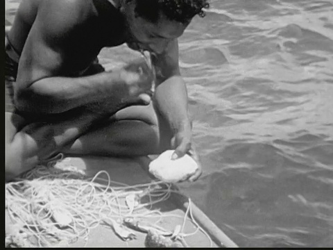 1949年，印第安人盘腿坐在独木舟的船头上，用石头做鱼饵钓鱼钩。马绍尔群岛的利基普视频下载