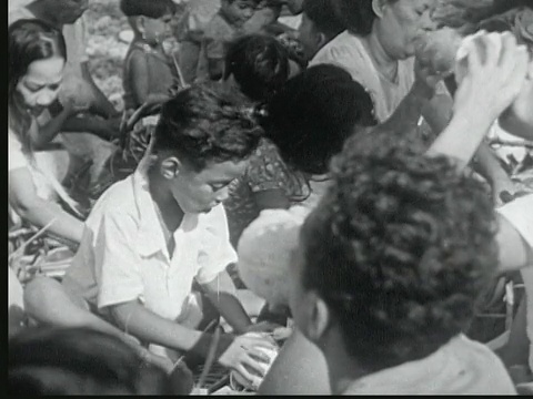 1949年蒙太奇儿童喝椰子汁。人们吃。马绍尔群岛，年轻女子喝着椰子汁，然后微笑着咬了一口面包视频下载