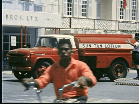 1963年，汉密尔顿繁忙的城市街道，交通繁忙。红色晒黑车，侧涂防晒油/汉密尔顿，百慕大视频素材