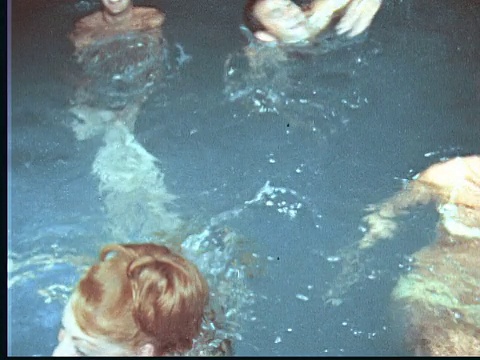 1966蒙太奇男人和女人在晚上在游泳池里嬉笑和戏水/百慕大视频素材
