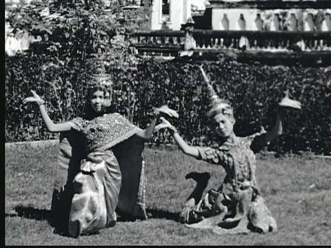 1948年B/W蒙太奇两个泰国年轻妇女穿着精心制作的服装和头饰表演缓慢的仪式舞蹈。曼谷,泰国视频下载