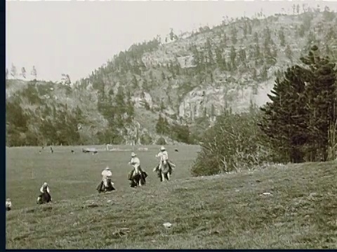 1924年蒙太奇蒙太奇，一群马在奔跑，戴着牛仔帽的人骑在马背上奔向摄像机视频下载