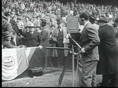 1945年黑白蒙太奇摄影师拍摄的赛马开始。两个男人在家看电视比赛。拉瓜迪亚市长抛出棒球。三脚架上的NBC摄像机。绉裥红蝙蝠。麦迪逊广场花园。金手套拳击。国会鼓掌/纽约市/音频视频下载