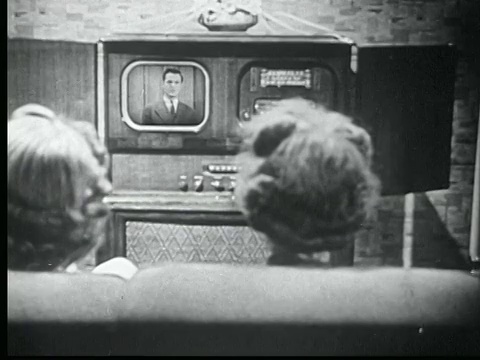 1945黑白蒙太奇两个女人坐在沙发上看电视。大电视，即将进入生产/美国/音频视频下载