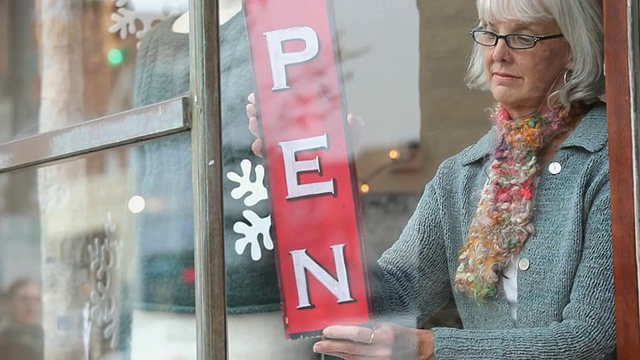 美国弗吉尼亚州里士满针织店店主在橱窗里放置开放标志视频下载