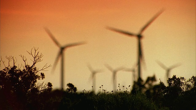 SLO MO WS R/F电厂和风力涡轮机的轮廓在日落的橙色天空/ Junction，美国德克萨斯州视频素材