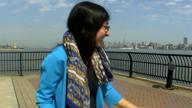 美国新泽西州泽西城，一对年轻的夫妇在码头上跳舞，背景是纽约的天际线视频素材