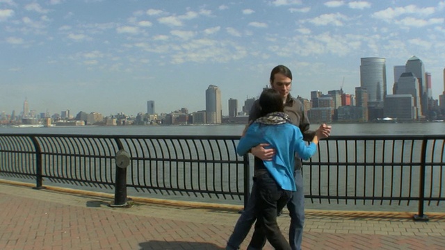 一对年轻的夫妇在新泽西码头上练习探戈舞，背景是纽约市/美国新泽西州泽西城视频素材