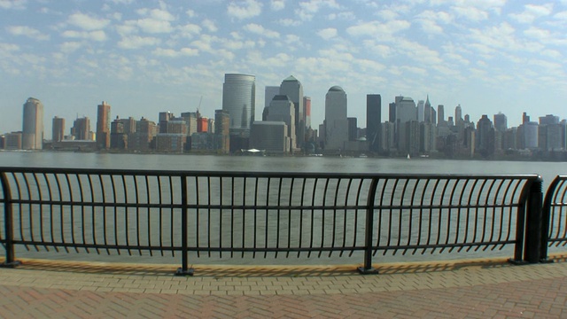 美国新泽西州泽西城，一对年轻的夫妇在码头上拥抱，背景是纽约市的天际线视频素材
