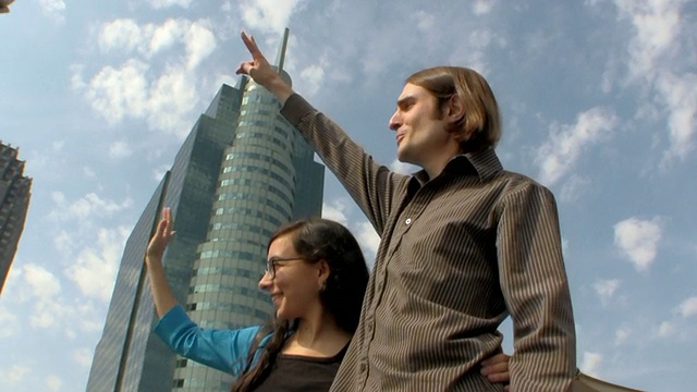 美国新泽西州泽西城，一对年轻的夫妇在背景中挥舞着建筑物视频素材