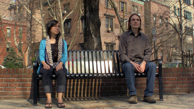 一对年轻的夫妇坐在长凳上看着对方/美国新泽西州泽西城视频素材