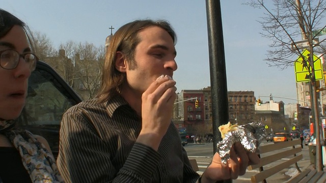 美国新泽西州，纽约市中心/泽西城，一对年轻夫妇在长凳上吃沙拉三明治视频素材