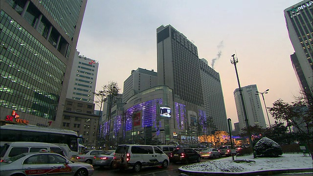 晚上街道上的交通，背景中的乐天百货商店/首尔，韩国视频下载