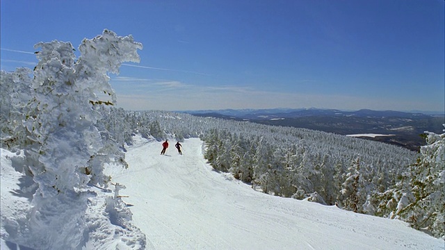 一对夫妇在新英格兰传统的积雪滑雪坡上滑雪/兰吉利，缅因州，美国视频素材