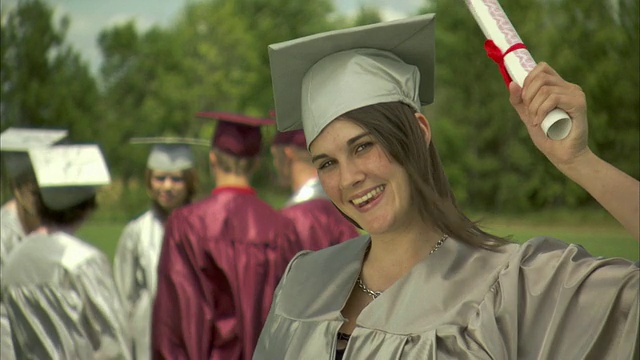 MS女毕业生前景回望朋友，向相机展示文凭/阿普尔顿，威斯康星州，美国视频下载