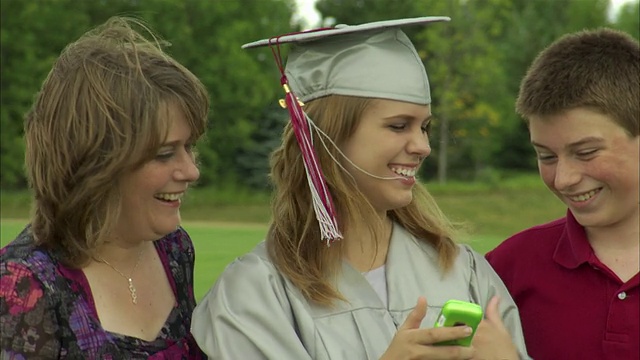 MS女毕业生用手机拍摄自己，母亲和兄弟(14-15岁)/阿普尔顿，威斯康星州，美国视频下载