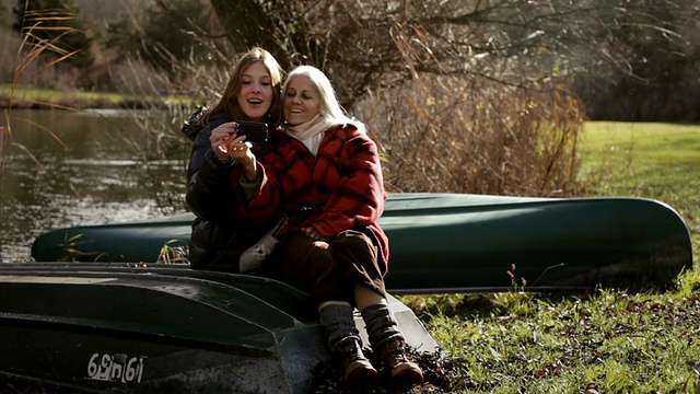 母亲和女儿坐在湖边，自拍/美国纽约金斯顿视频素材