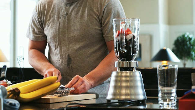 厨房里的男人正在用搅拌机做水果奶昔视频下载