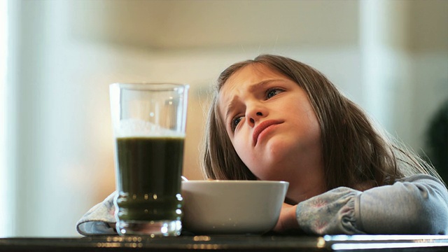 小女孩吃麦片，抱怨喝了健康的绿色奶昔视频下载