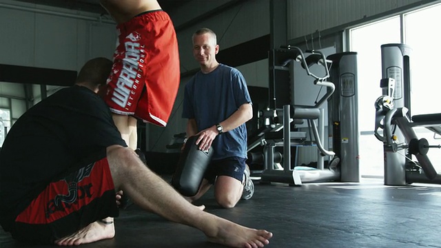 训练师和一名男子一起训练他进行综合格斗视频素材