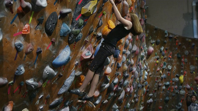 少女自由攀登室内攀岩墙视频素材