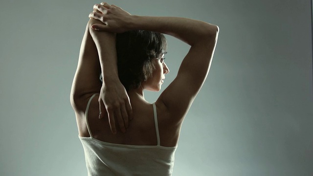 SLO MO MS妇女揉她的背和伸展在工作室/纽约市，纽约州，美国的后视图视频素材