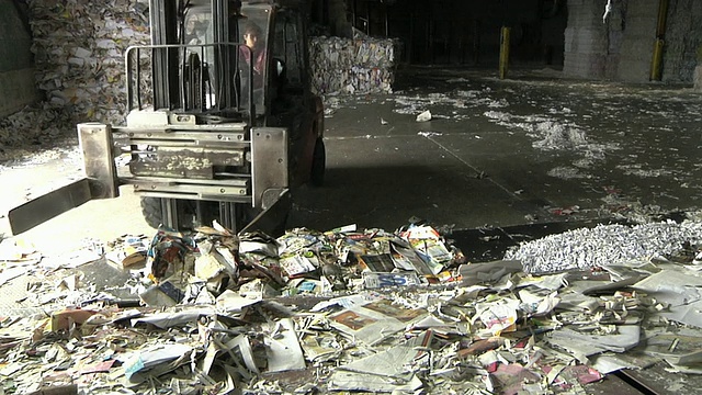 美国密歇根州造纸厂/ Manistique，叉车操作员搬运成捆的再生纸和消费后废物视频下载