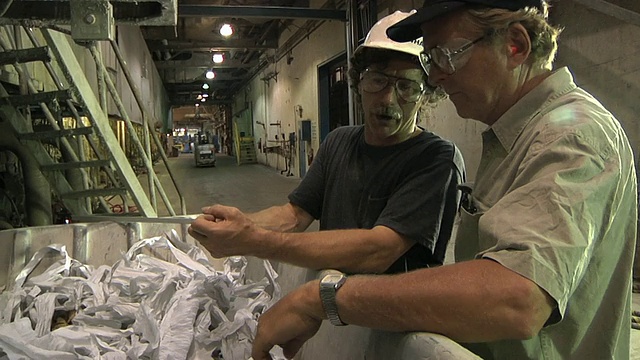 MS造纸厂的工人在看废纸回收/ Manistique期间产生的废物，密歇根州，美国视频下载