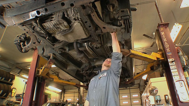MS ZO汽车机械师检查起落架车在汽车修理店/切尔西，密歇根州，美国视频下载